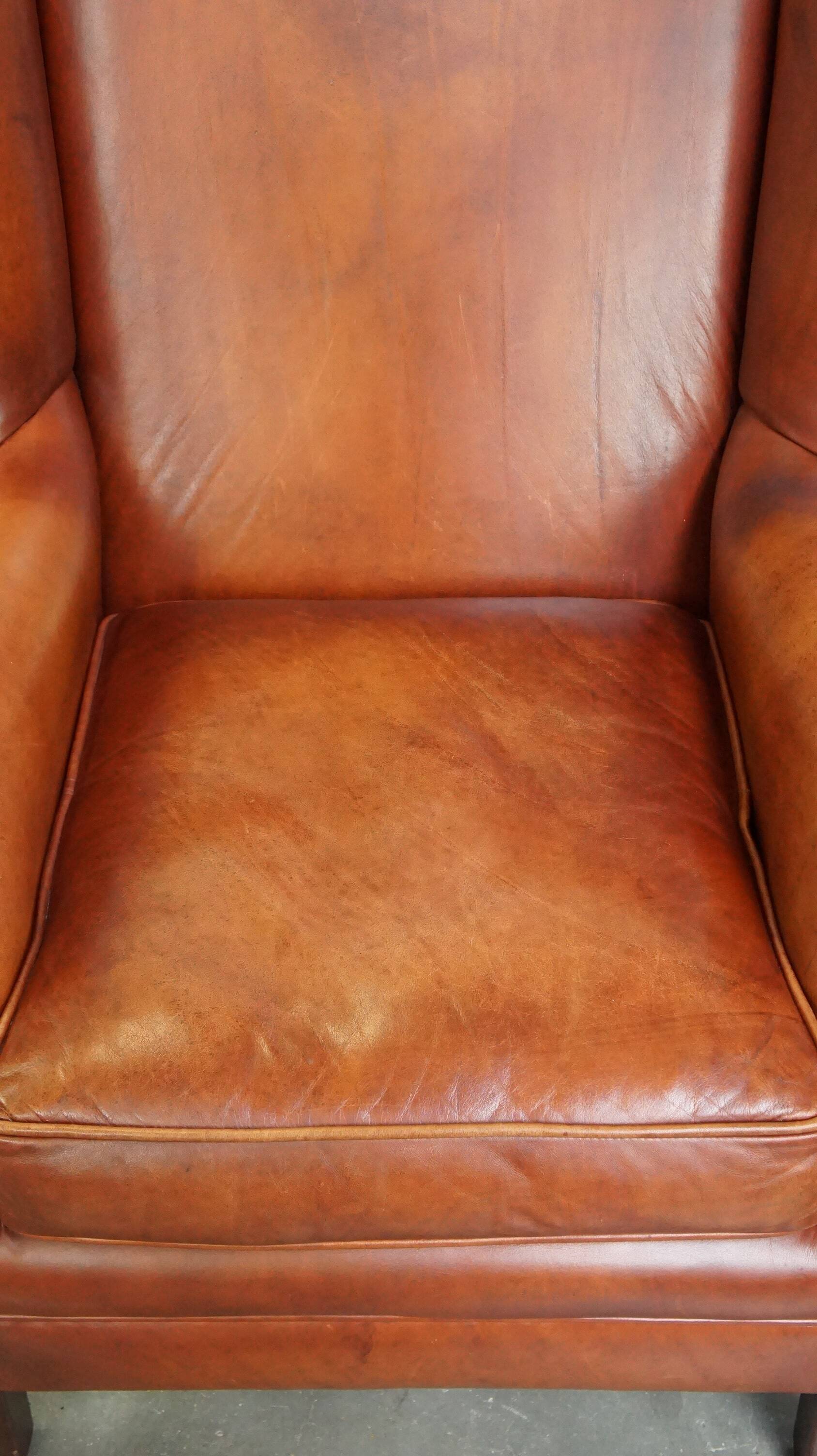 Fauteuil en cuir confortable et bien entretenu, fini avec des clous décoratifs de style anglais