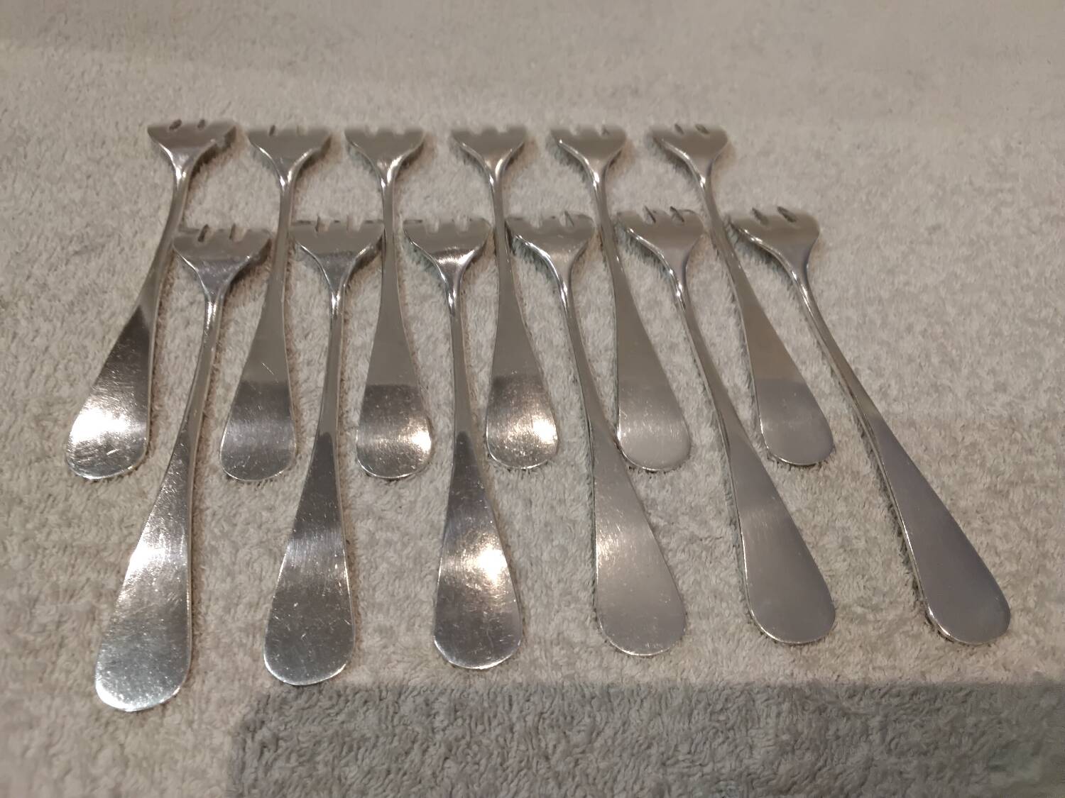 12 silver-plated oyster forks by silversmith J Brille with stick handles.