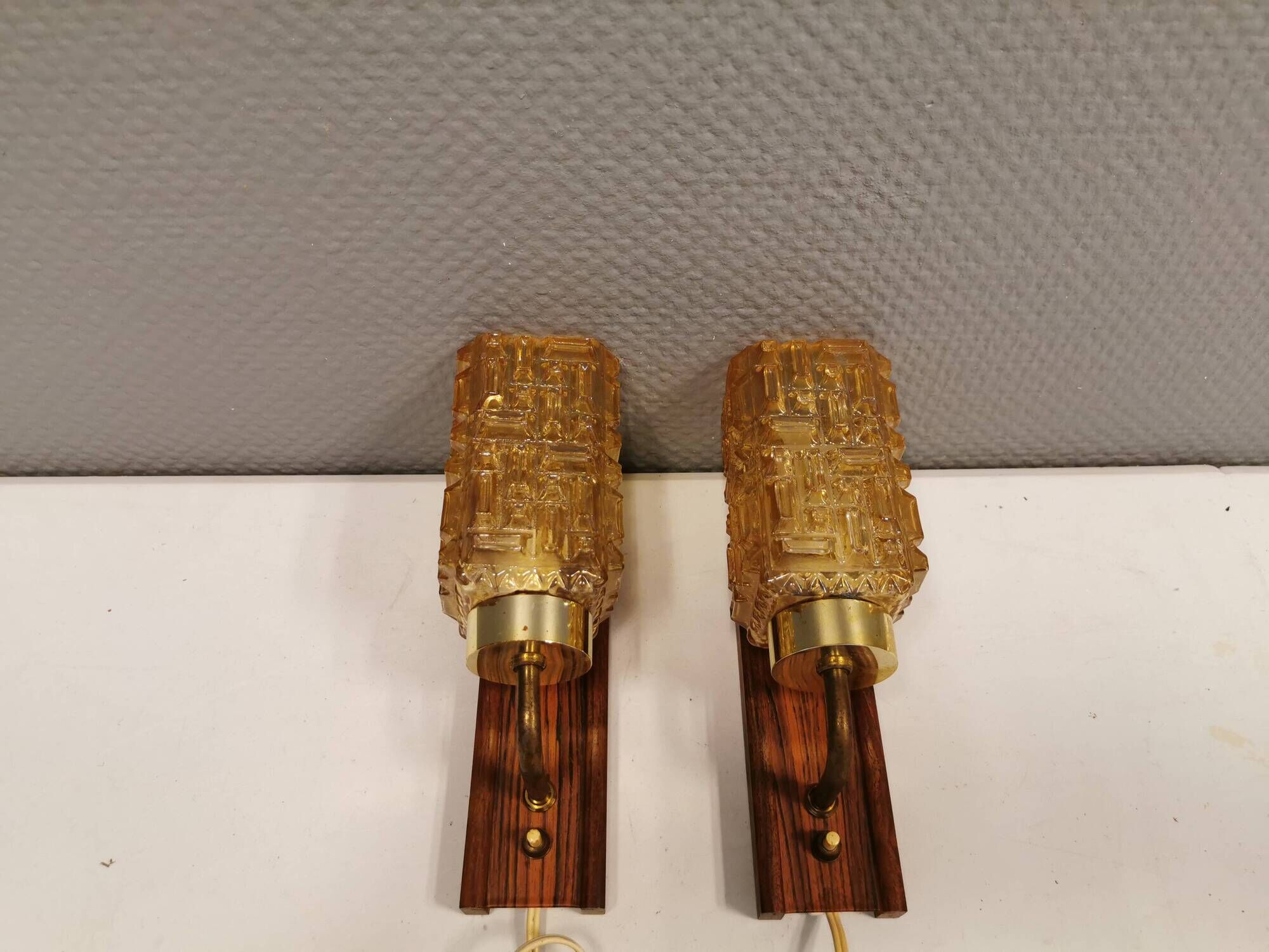 wall lights in rosewood look, with amber coloured glass and brass details.