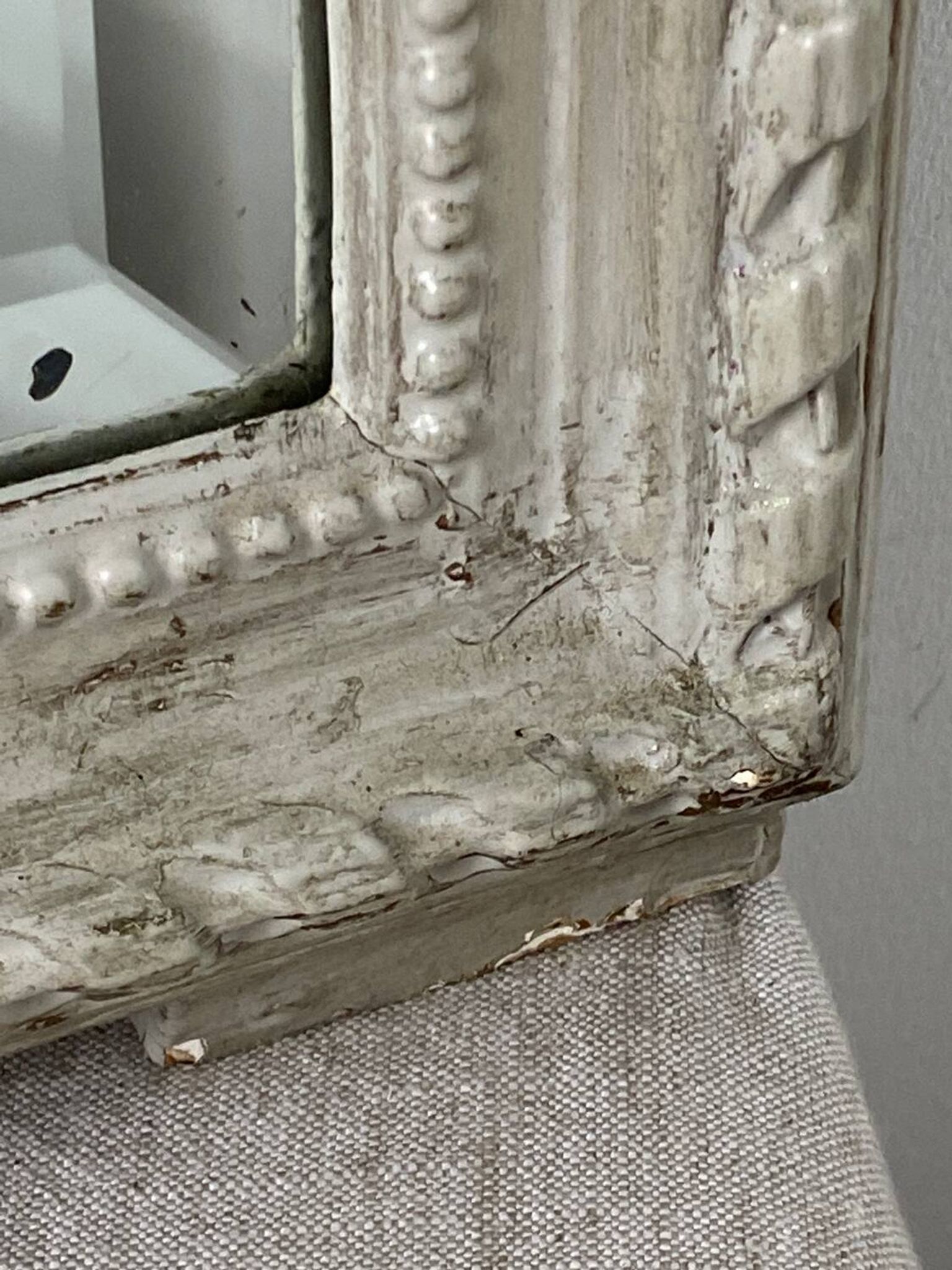 Large antique beveled mirror in carved wood painted with floral decoration and