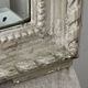 Large antique beveled mirror in carved wood painted with floral decoration and