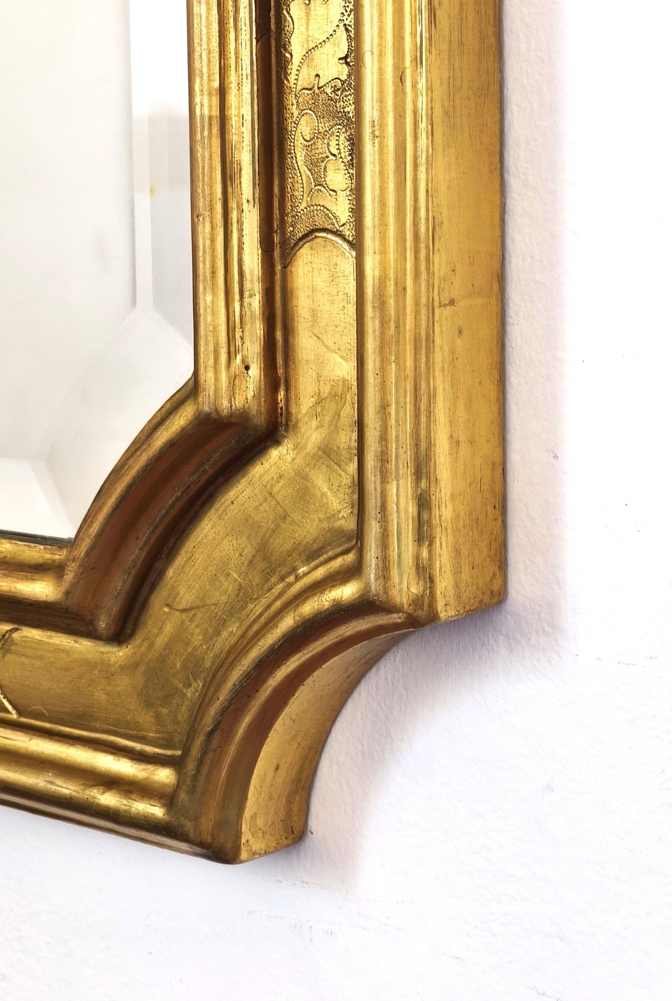 Florentine arched mirror in gilded wood with gold leaf.
