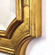 Florentine arched mirror in gilded wood with gold leaf.