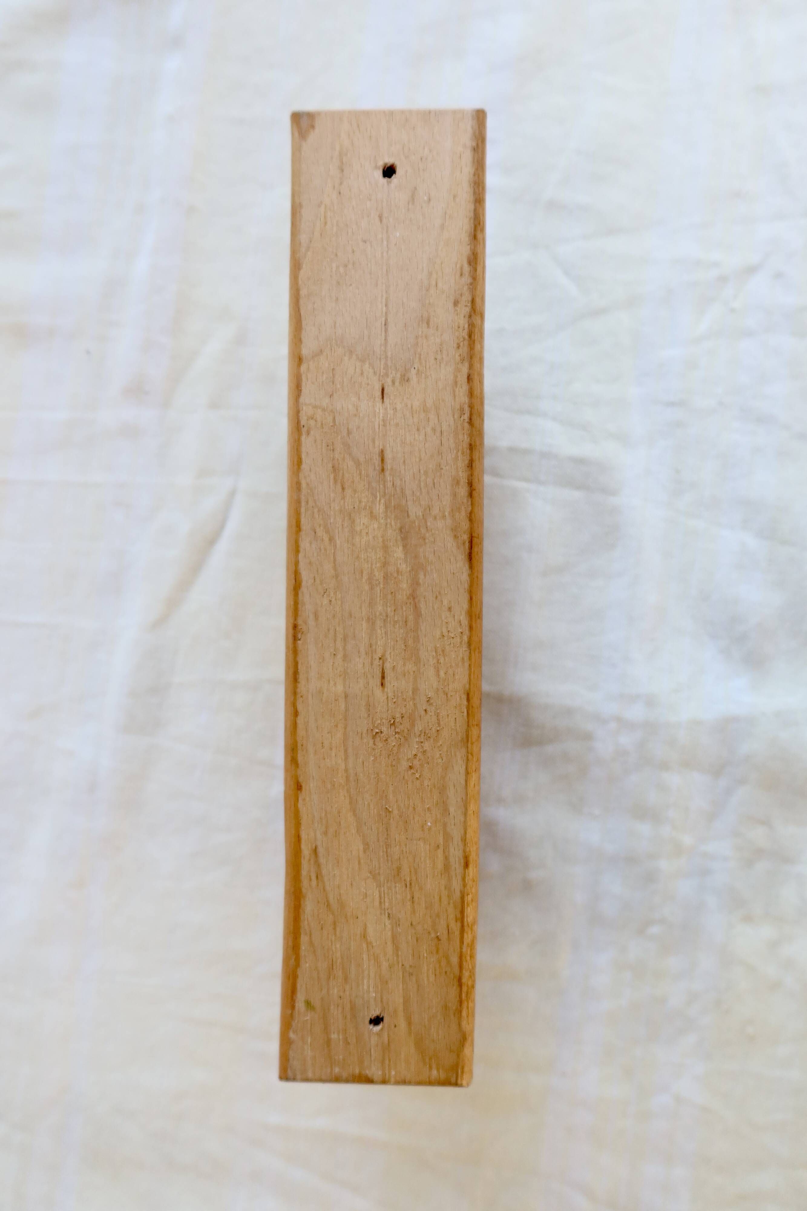 Vintage wooden coat rack with two round hooks.