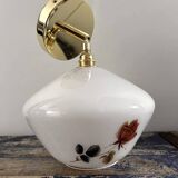 Golden tilting wall light with flowered globe