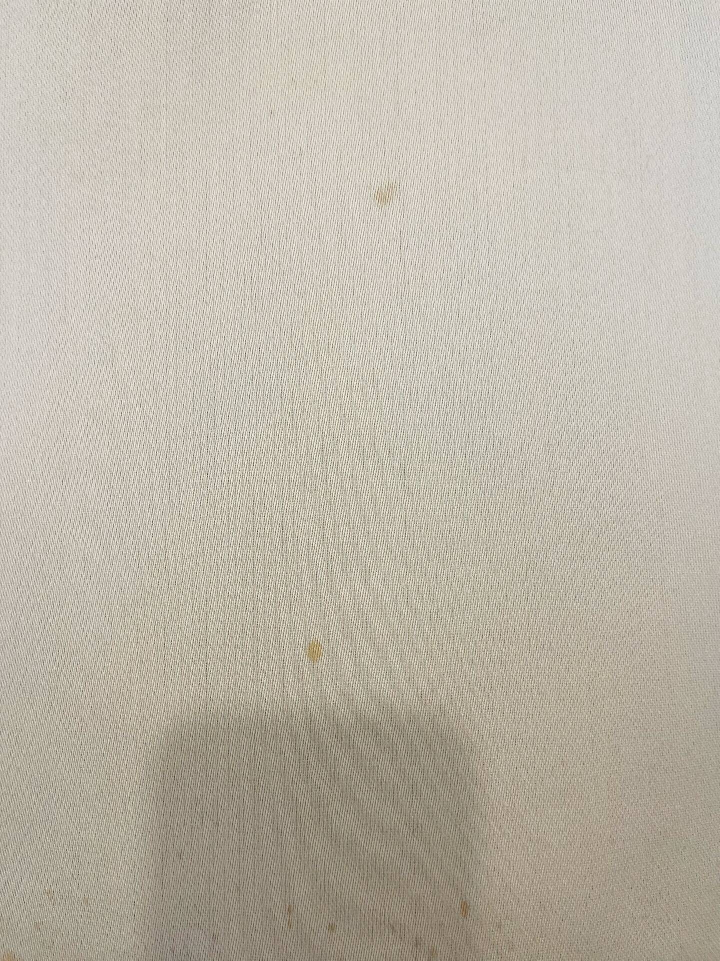 Pale pink upholstered armchair with wooden legs.