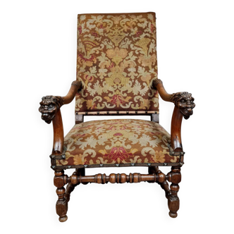Renaissance armchair in carved walnut with lion head decoration