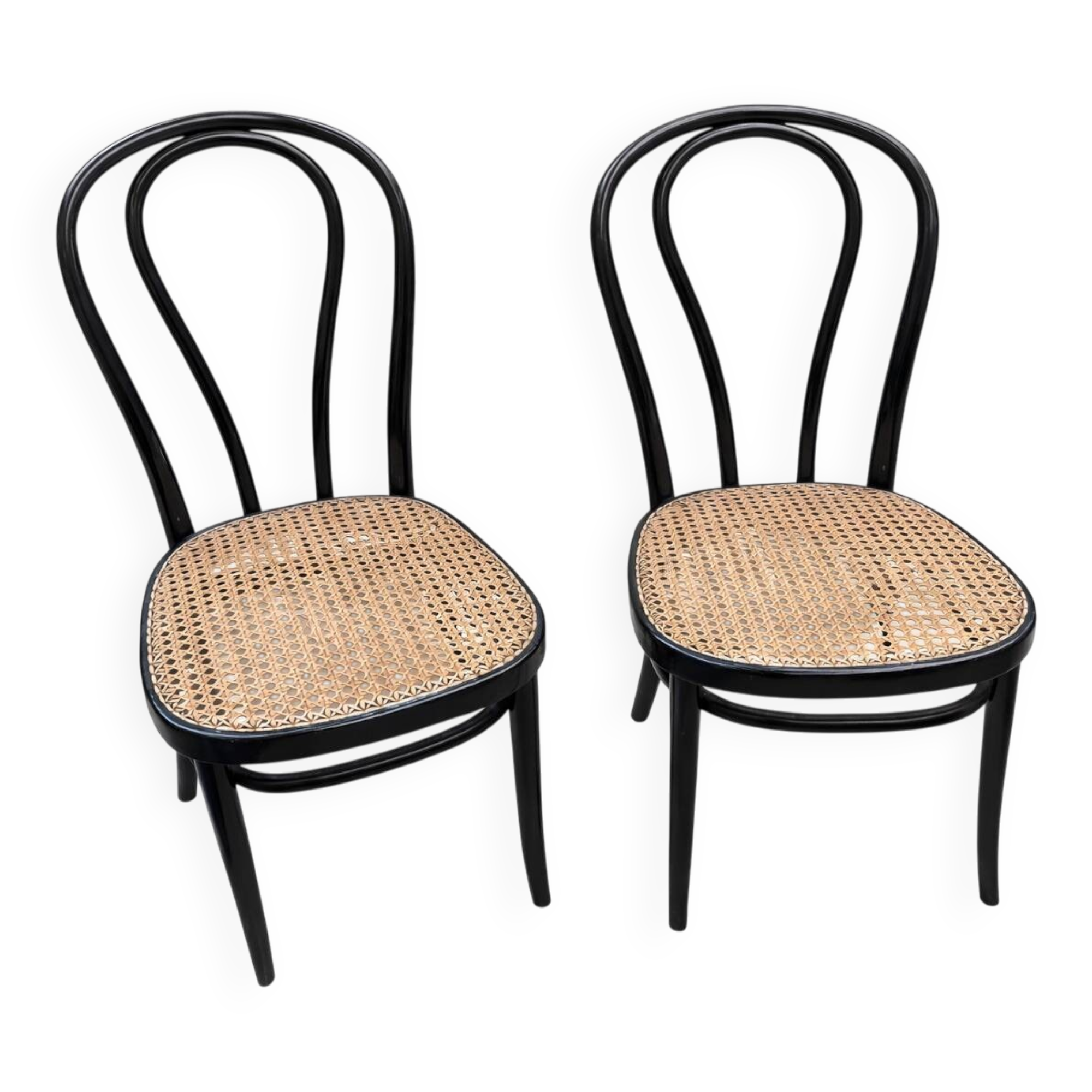 Pair of black curved wooden bistro chairs with caning in Thonet style.