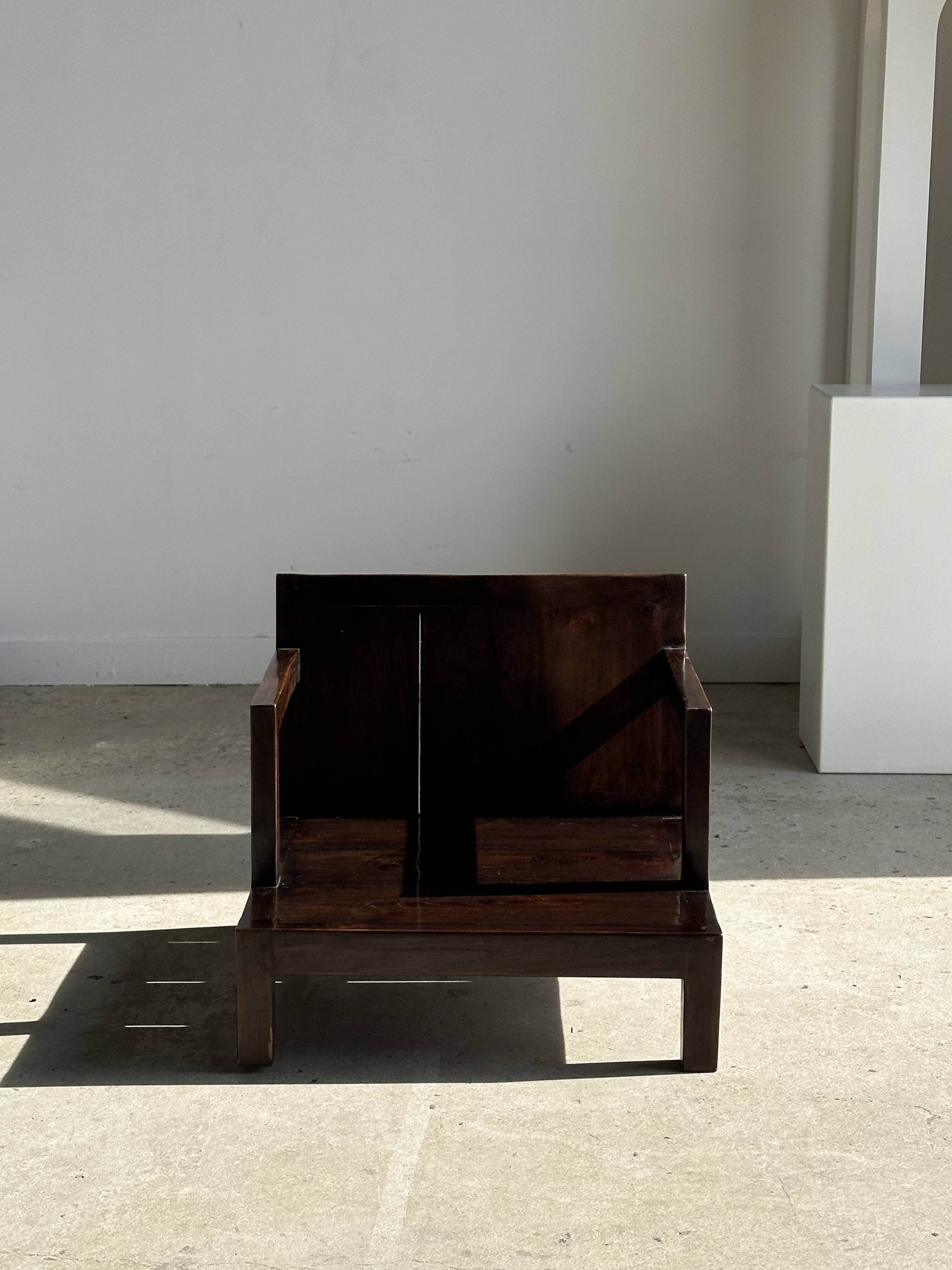 Small low armchair in varnished brown wood