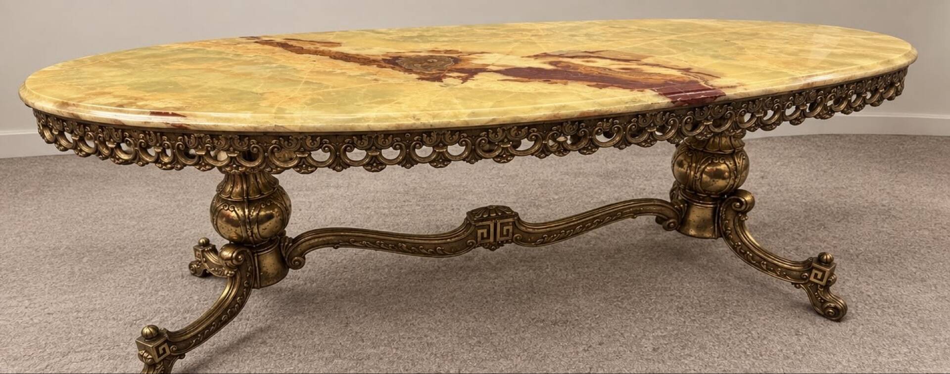 Large oval coffee table in yellow marble and gold metal, classic style.