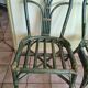 Round rattan table with glass top and 4 green rattan chairs.