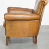 Beautiful and comfortable sheepskin armchair, finished with decorative nailheads
