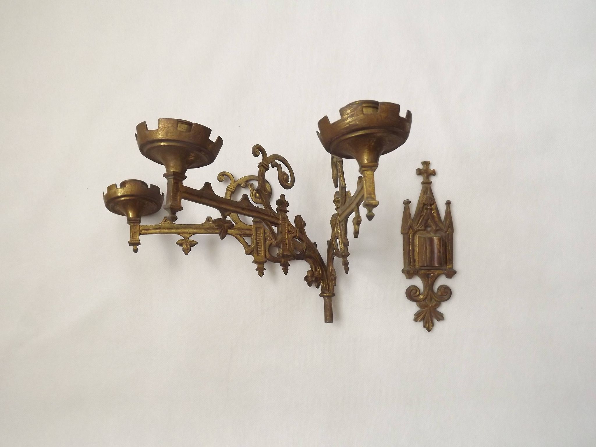 Ensemble élégant de trois appliques murales en bronze doré de style gothique français.