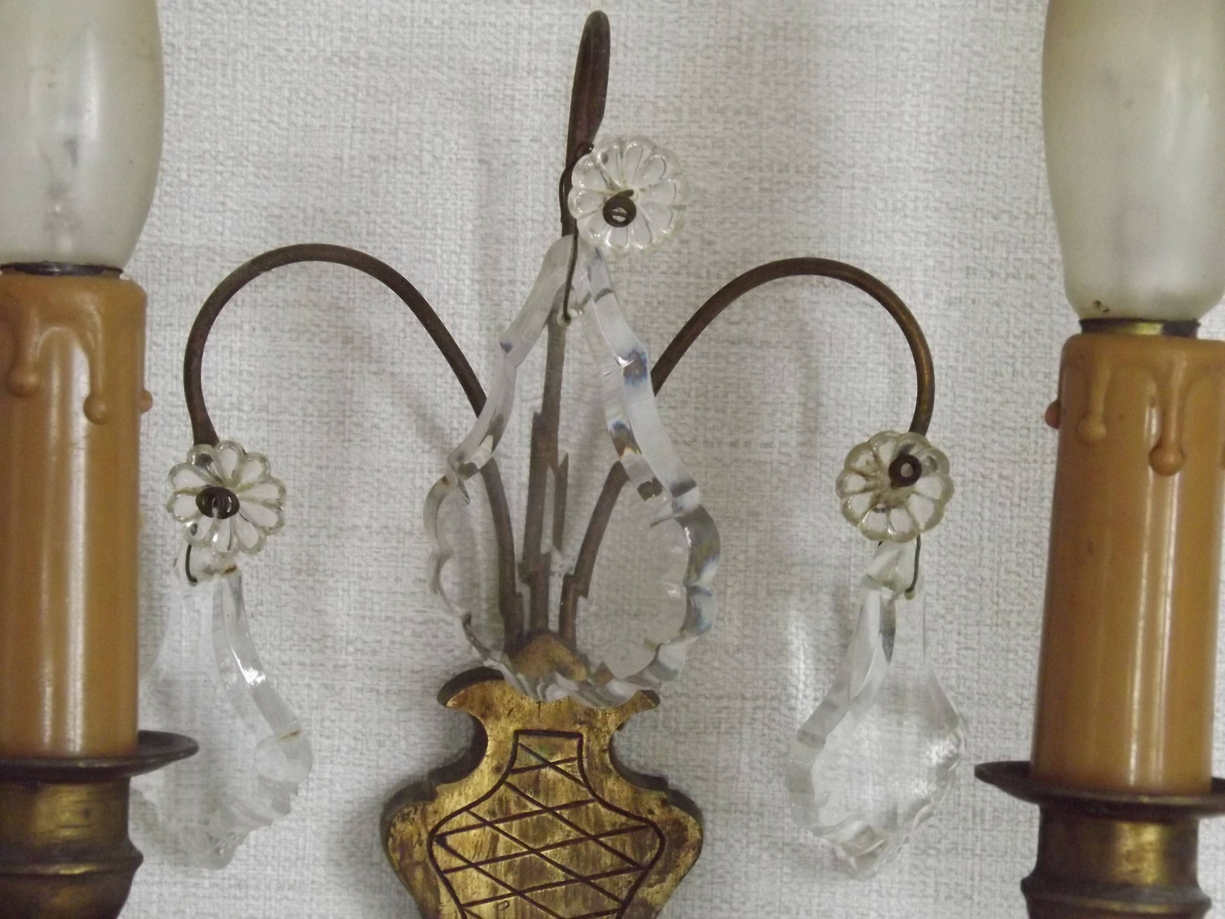 Pair of French antique brass double wall lights with assorted crystals.