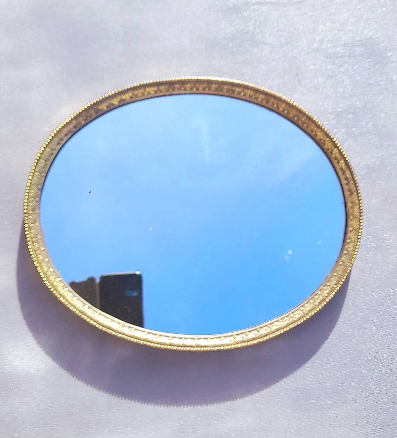 Oval mirror in gold metal