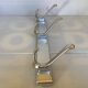 Stainless steel coat rack with three double hooks.