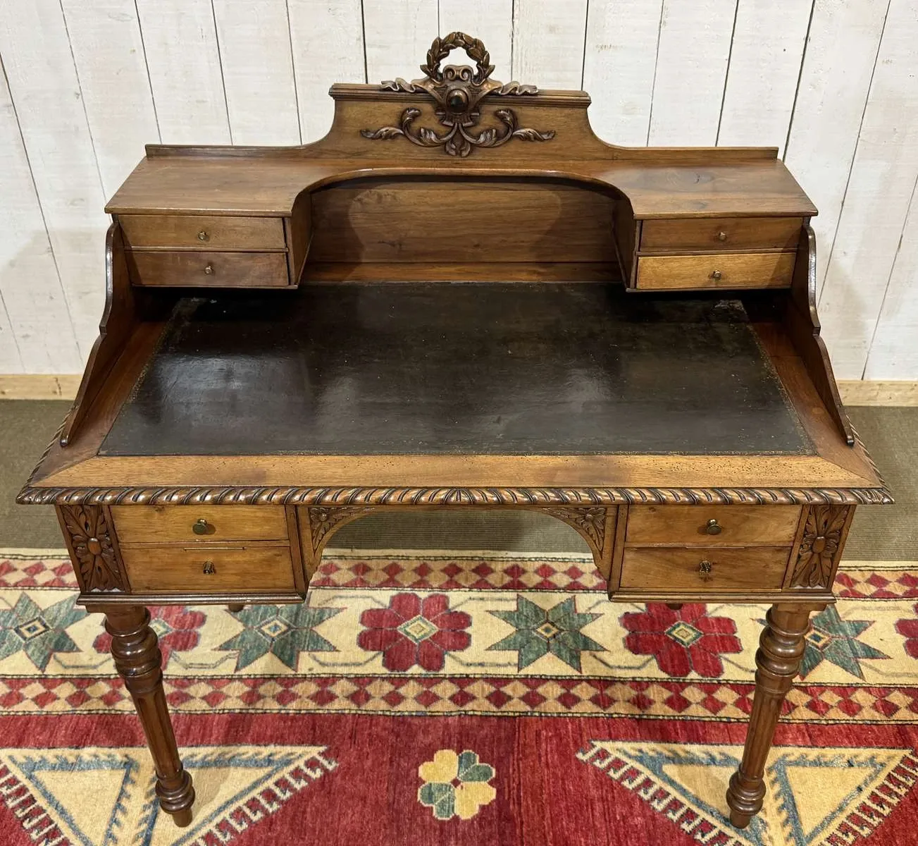 Louis XVI style desk from the late 19th century in walnut with a leather top.