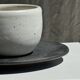 White Indonesian ceramic cup and gray saucer