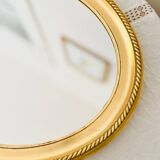 Oval wall mirror in gilded wood