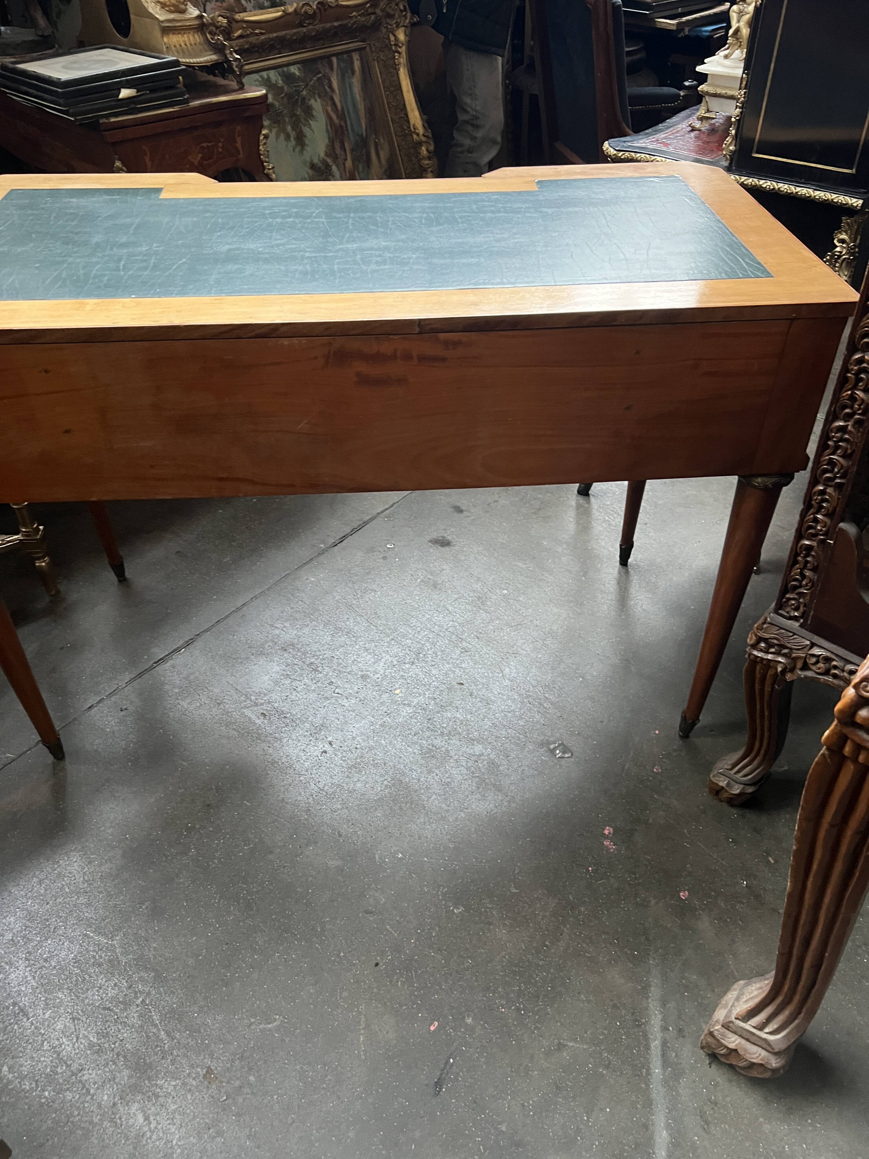 Louis XVI style marquetry desk. The top is decorated with green leather.