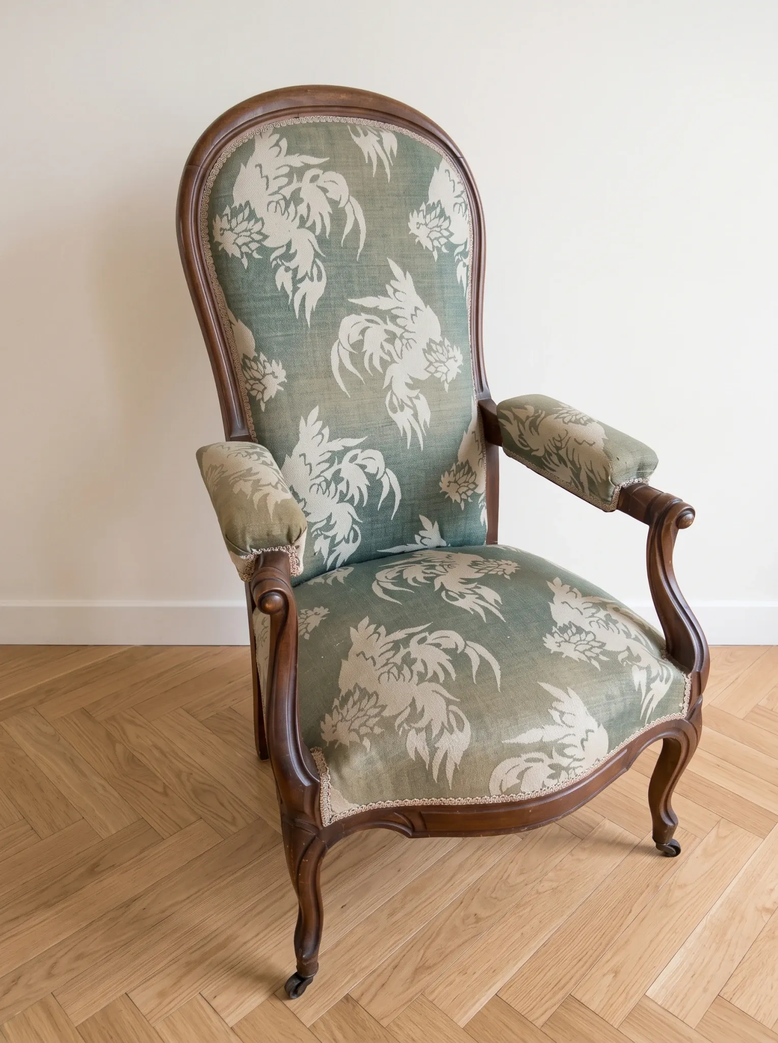 Antique Voltaire armchair in wood and green fabric with floral patterns.