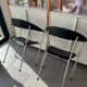 Set of two metal chairs with a brushed finish and black leather.