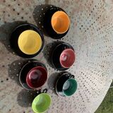 Coffee service composed of 5 cups and saucers in black earthenware and different colored interiors