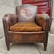 Antique club chair in patinated brown leather, early 20th century English style.