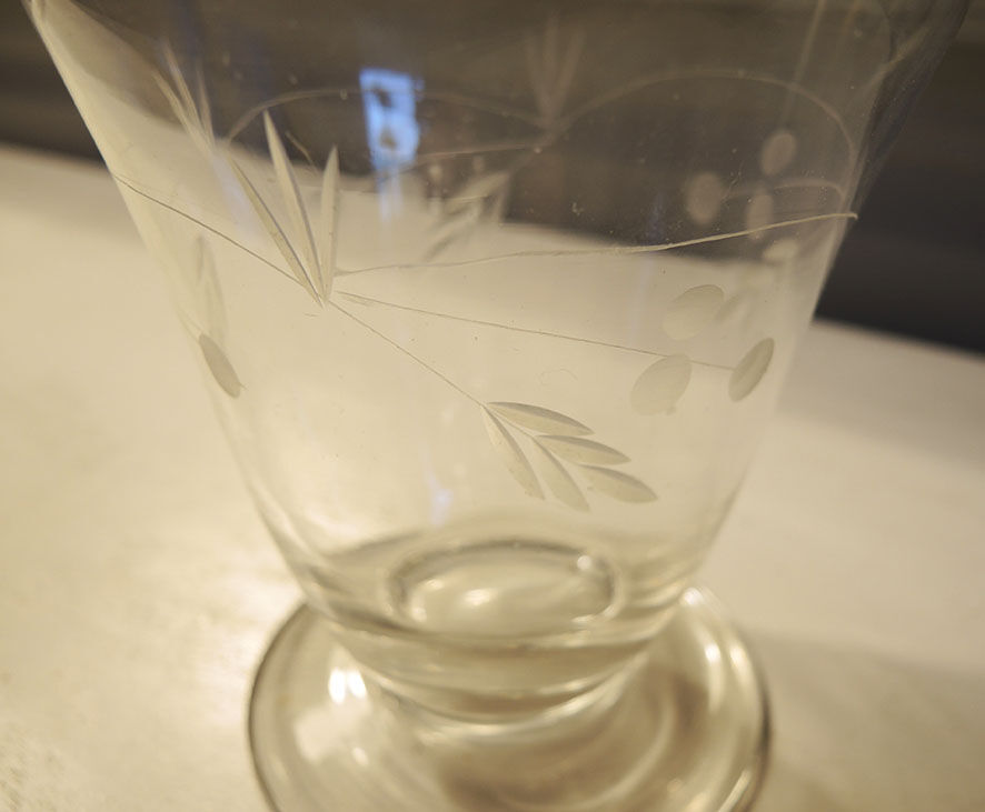 Old carafe in engraved glass vegetal decoration