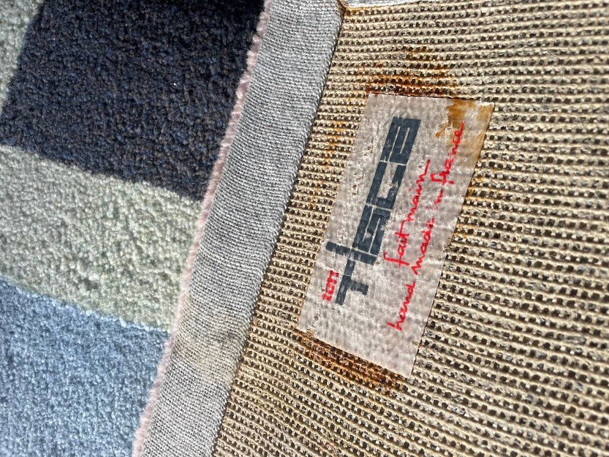 Hand-knotted wool rug by Tisca with a geometric pattern, signed "ILES", France, 1990s.