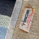 Hand-knotted wool rug by Tisca with a geometric pattern, signed "ILES", France, 1990s.