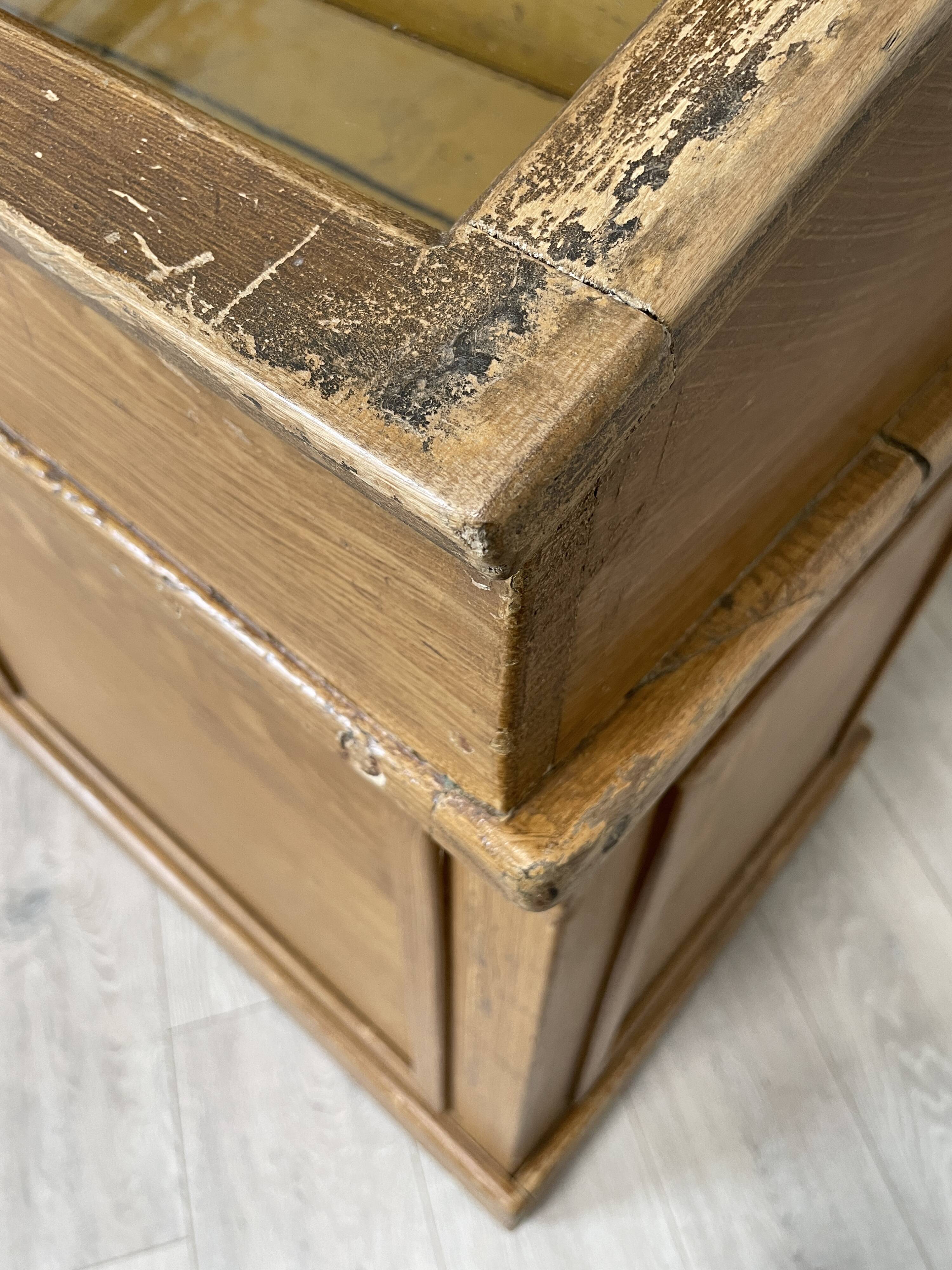 Wooden hardware cabinet painted with wood effect, circa 1940.