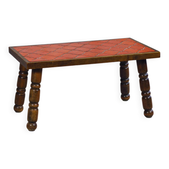 Brutalist coffee table in orange ceramic and solid wood.