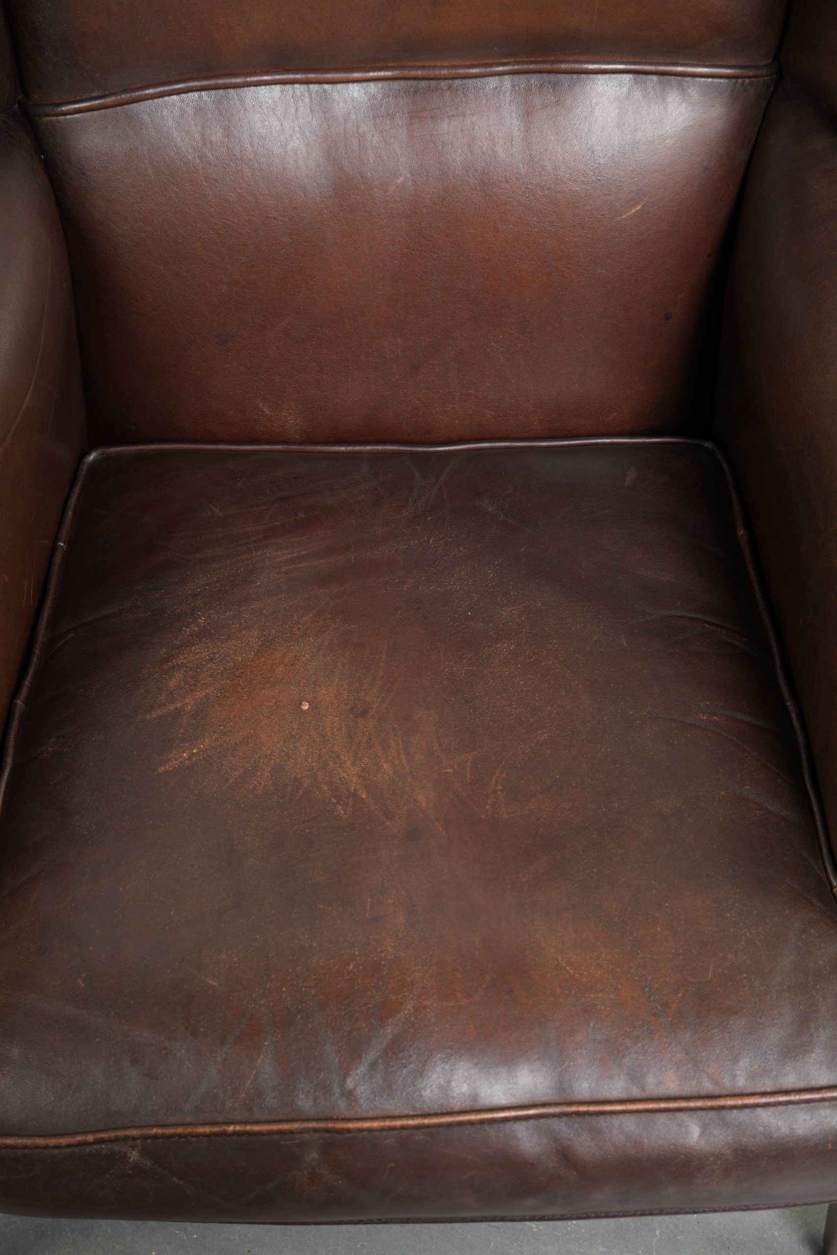 Subtle sheepskin wingback armchair with a deep cognac colour