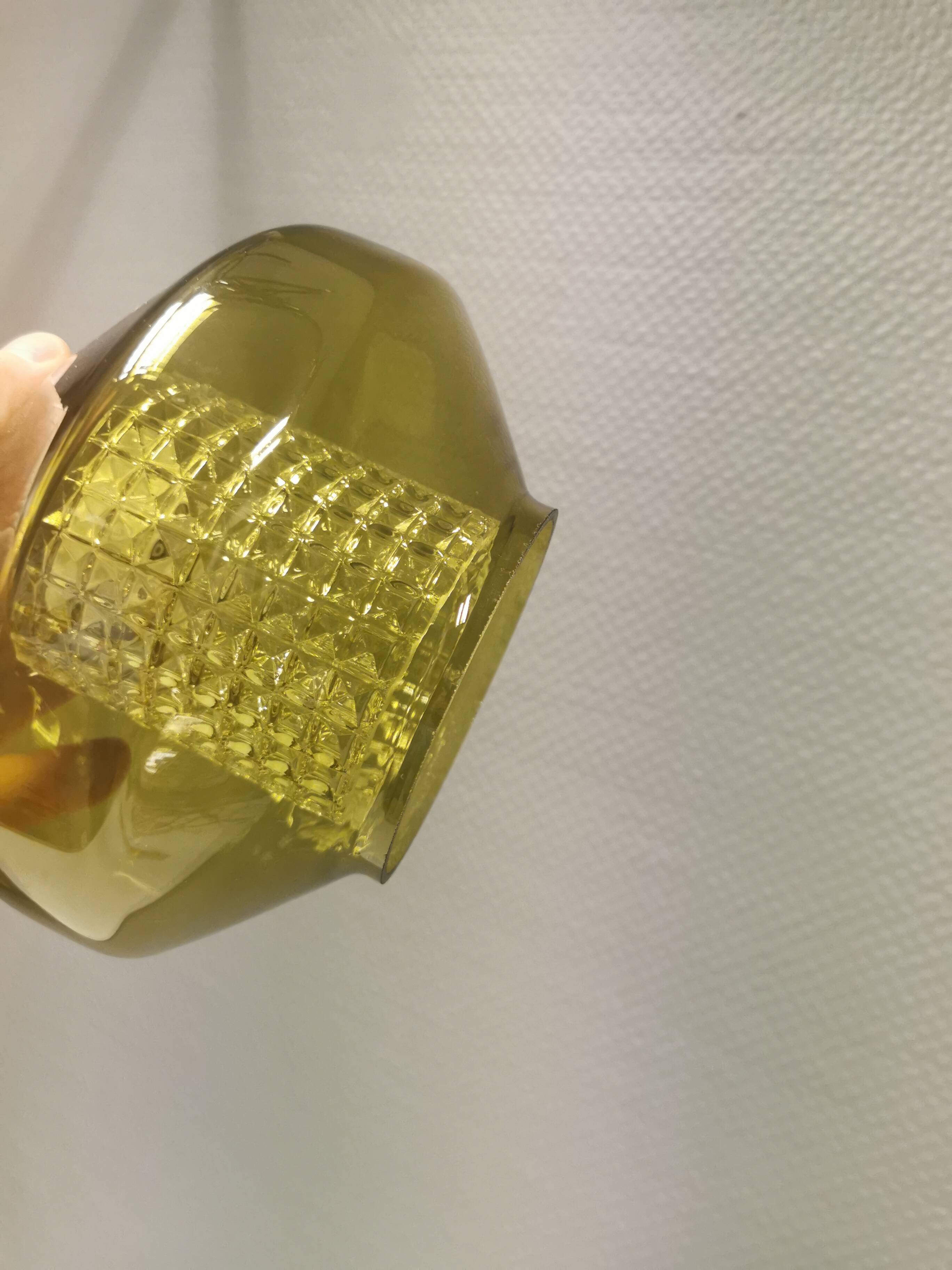 Hanging lamp with an outer shade of olive green glass and an inner shade of clear, crystal glass.