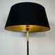 Lampadaire de parquet design en métal laqué noir et laiton intégrant un porte-revues