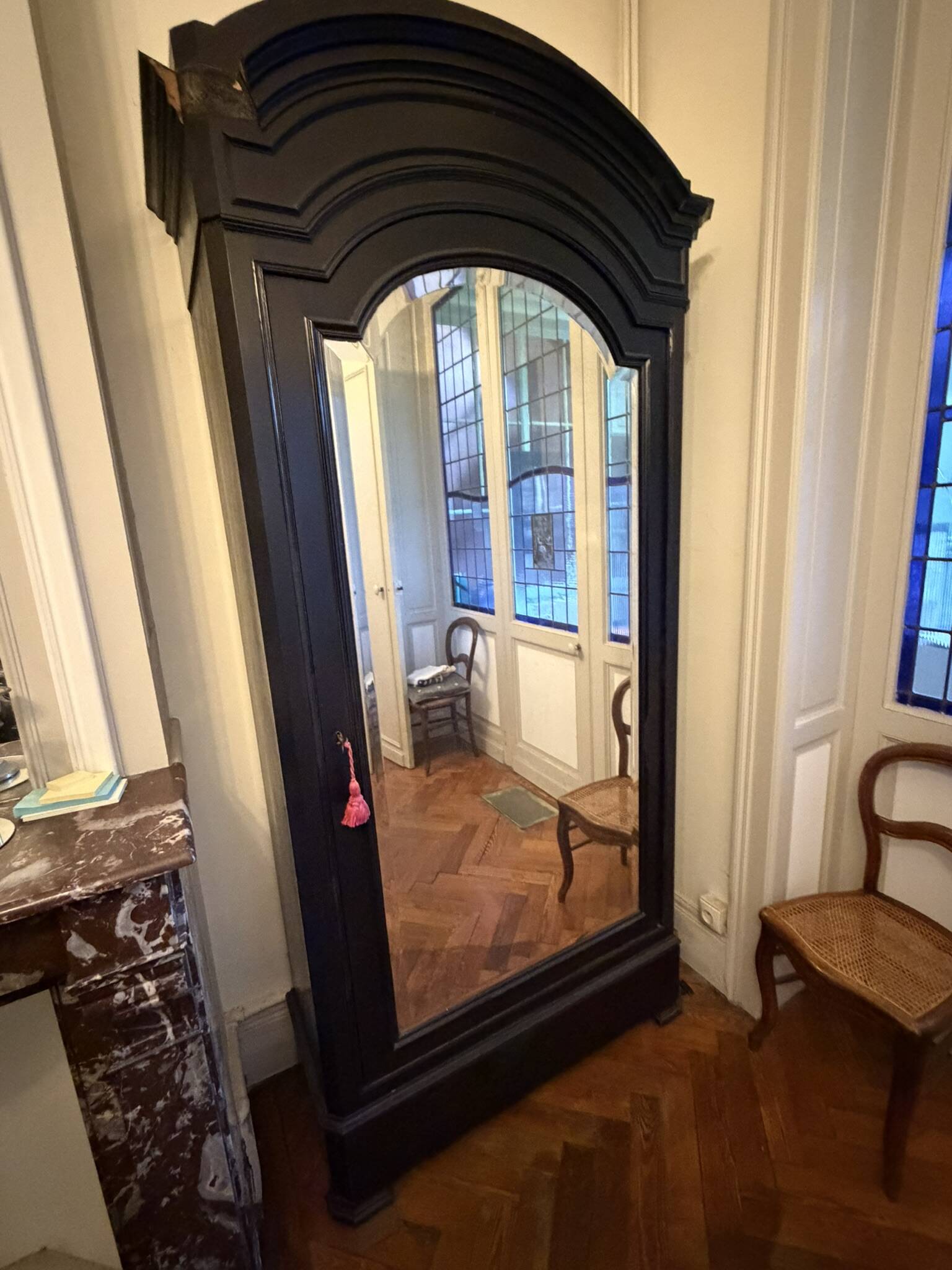 Black wardrobe with a mirrored door in ebony finish.