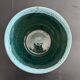Green cache pot with a foam trim.