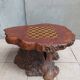 Brutalist chessboard coffee table made from tree stump.