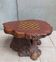 Brutalist chessboard coffee table made from tree stump.