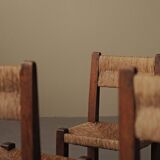Set of four modernist chairs in oak and straw, France, circa 1960.