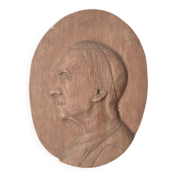 Oval wooden relief portrait of a cardinal.