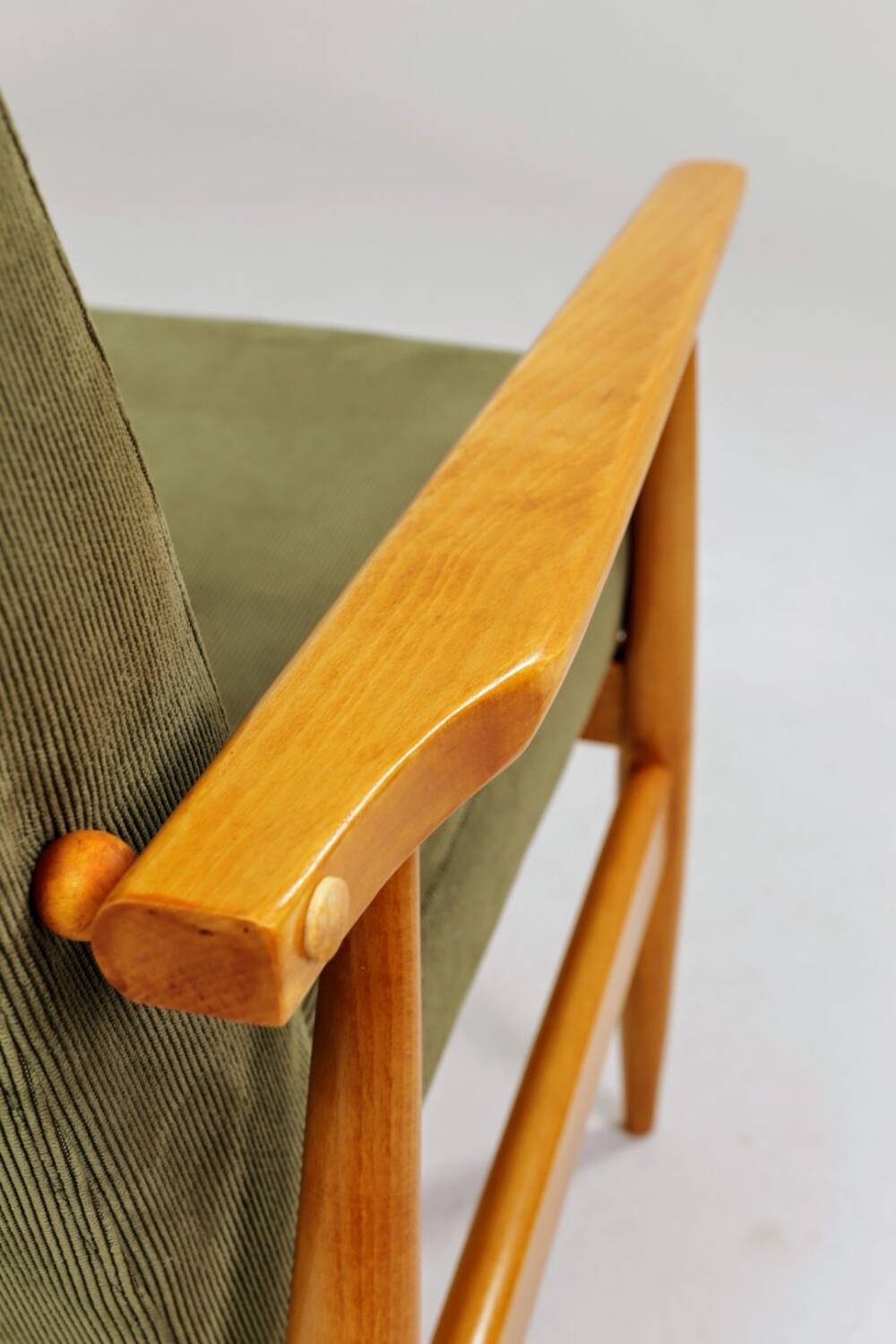 Mid-century modern design armchair in olive green corduroy.