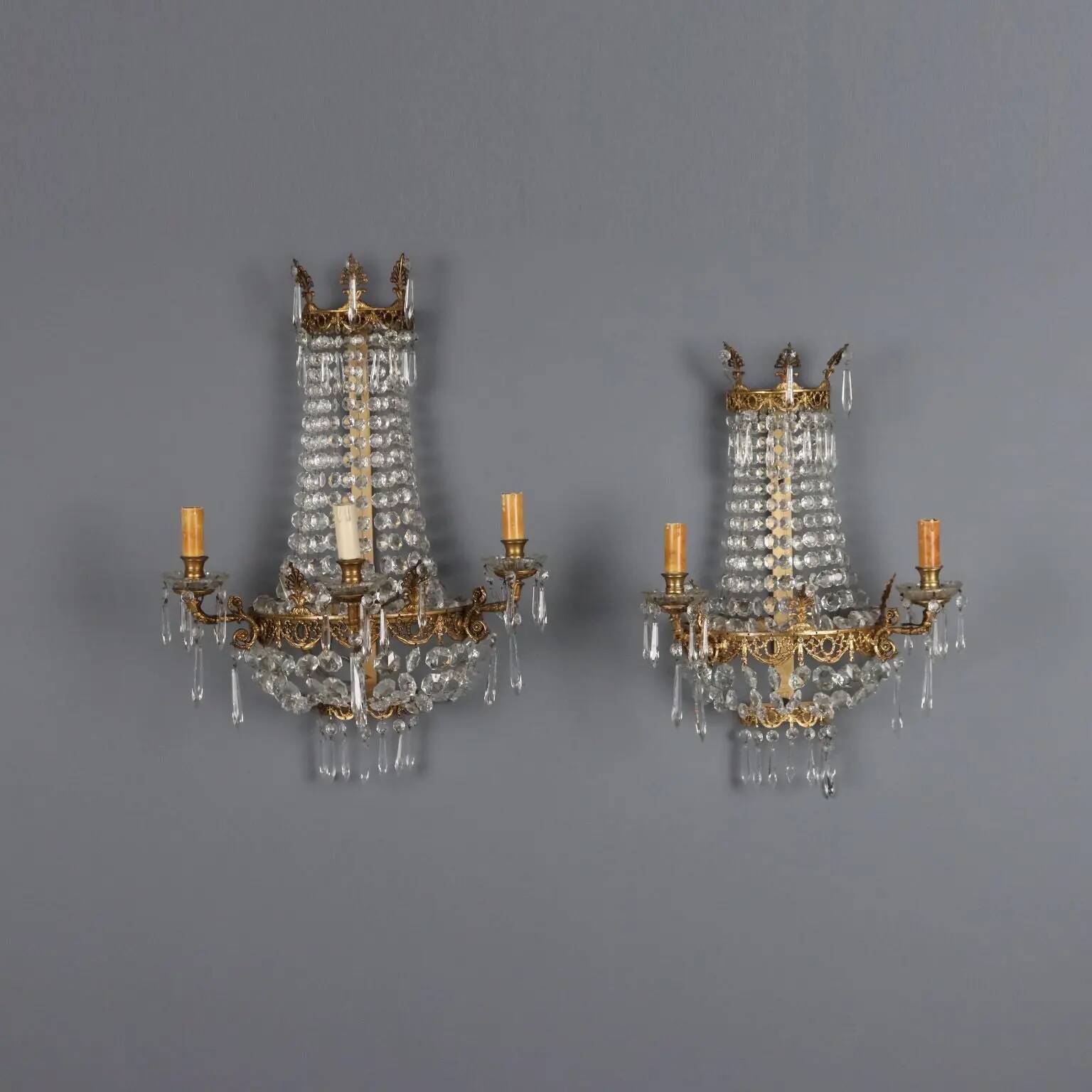 Antique wall sconces in gilded bronze with neoclassical motifs, 20th century.
