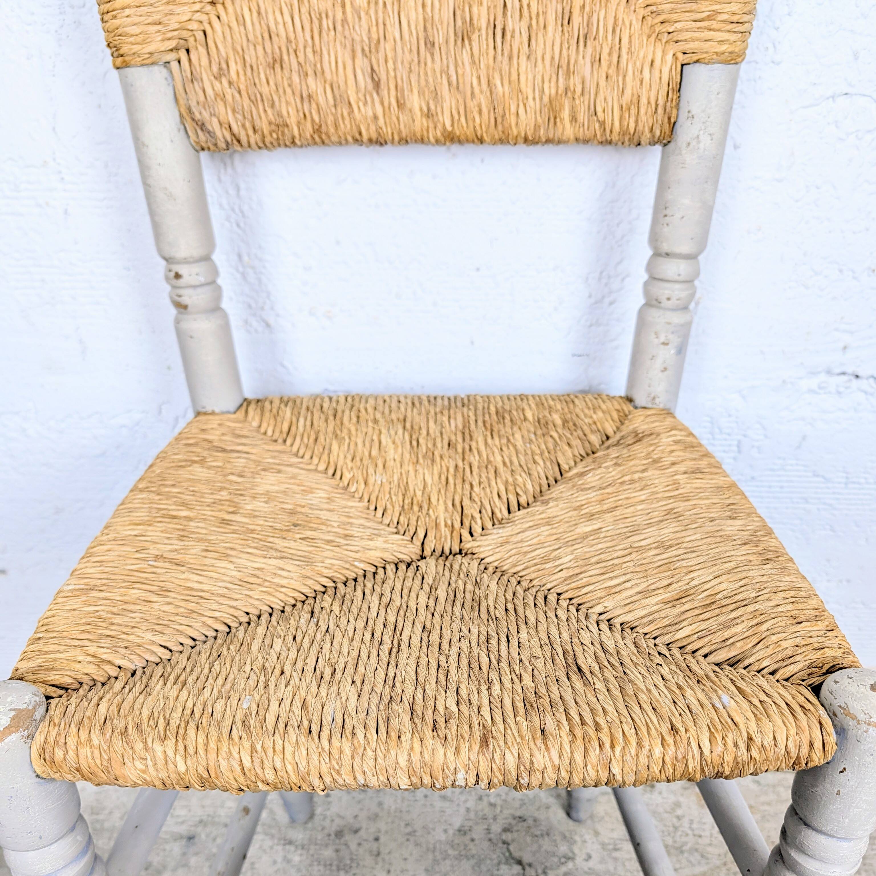 Rustic chair made of turned wood and straw.