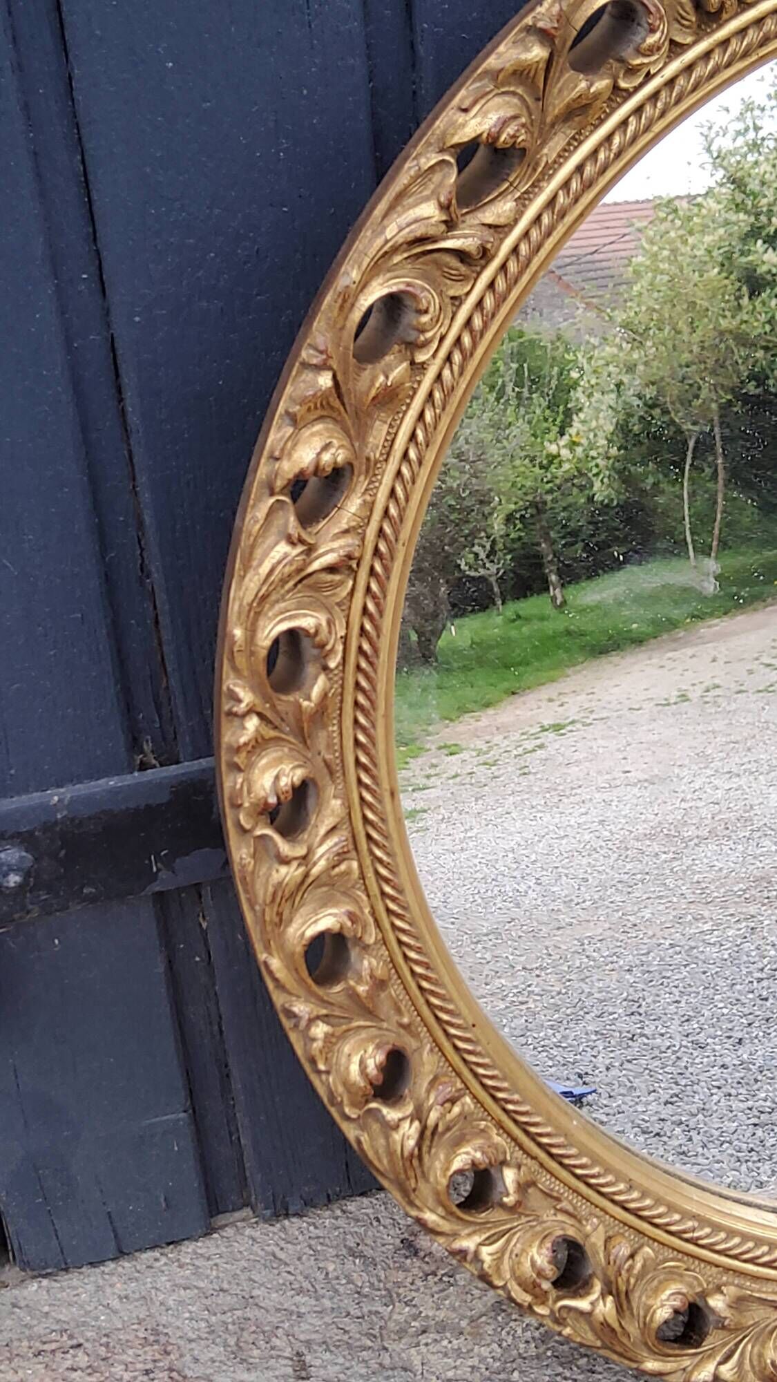 Round neoclassical style mirror in wood and gilded stucco from the 1950s