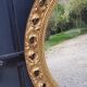 Round neoclassical style mirror in wood and gilded stucco from the 1950s