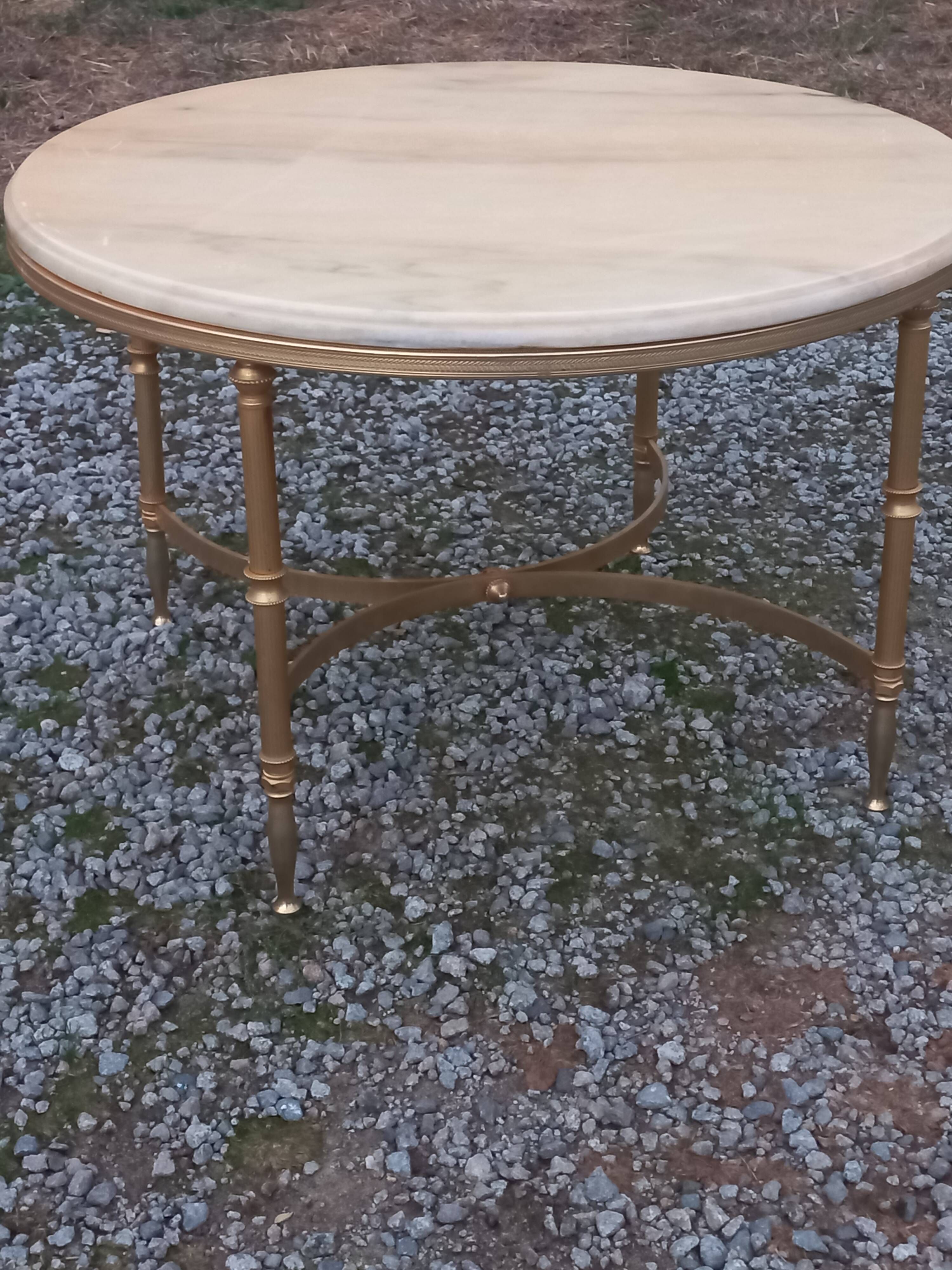 Round neoclassical coffee table with a marble top and golden metal base.
