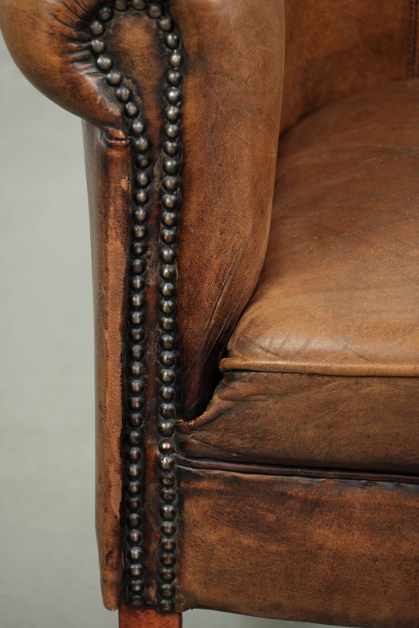 Sheepskin club armchair in a brown colour finished with decorative nails