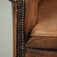 Sheepskin club armchair in a brown colour finished with decorative nails